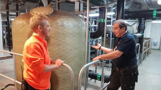 Robert, som jobbar tätt tillsammans med personalen uppe i själva badanläggningen, visar Andreas Lutmark, simlärare, hur vattenreningssystemet fungerar.