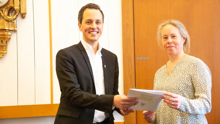 Lena Neij, ordförande i Lunds kommuns klimatpolitiska råd lämnar över 2020 års rapport till Philip Sandberg (L), kommunstyrelsens ordförande i Lunds kommun.