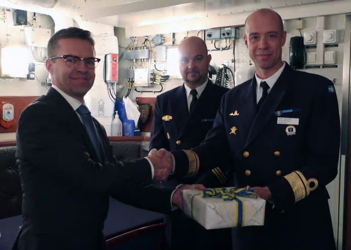Sjöfartsverkets produktchef Magnus Wallhagen överlämnar djupdata till försvarets marinchef Jens Nykvist. Med på bilden är även Magnus Ström som deltagit i sjömätningen.