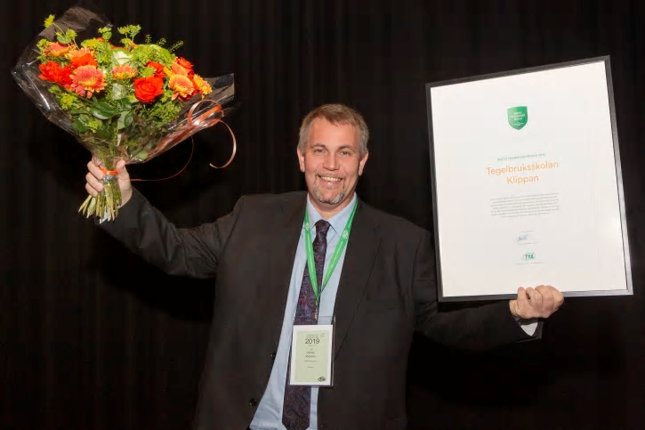 Tegelbruksskolans biträdande rektor Johan Jönsson tar emot priset &Aring;rets Transportskola 2019.