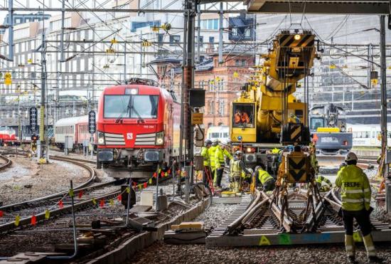 Med Vossloh Nordics spårgående Kirow-kran kan trafiken köra som normalt förbi arbetsplatsen. Här passerar Snälltåget förbi precis utanför Stockholms centralstation.