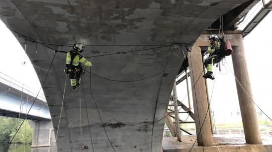 Reparbetare utför broinspektion.